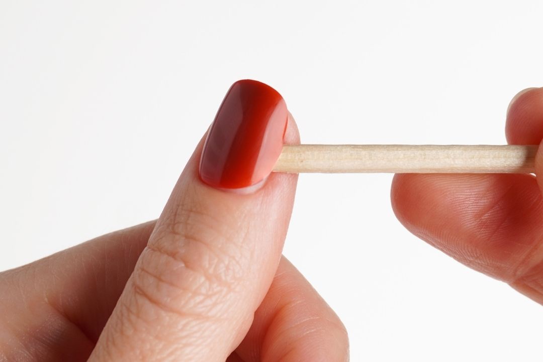 Press On Nagel wird mit einem Rosenholzstäbchen entfernt.